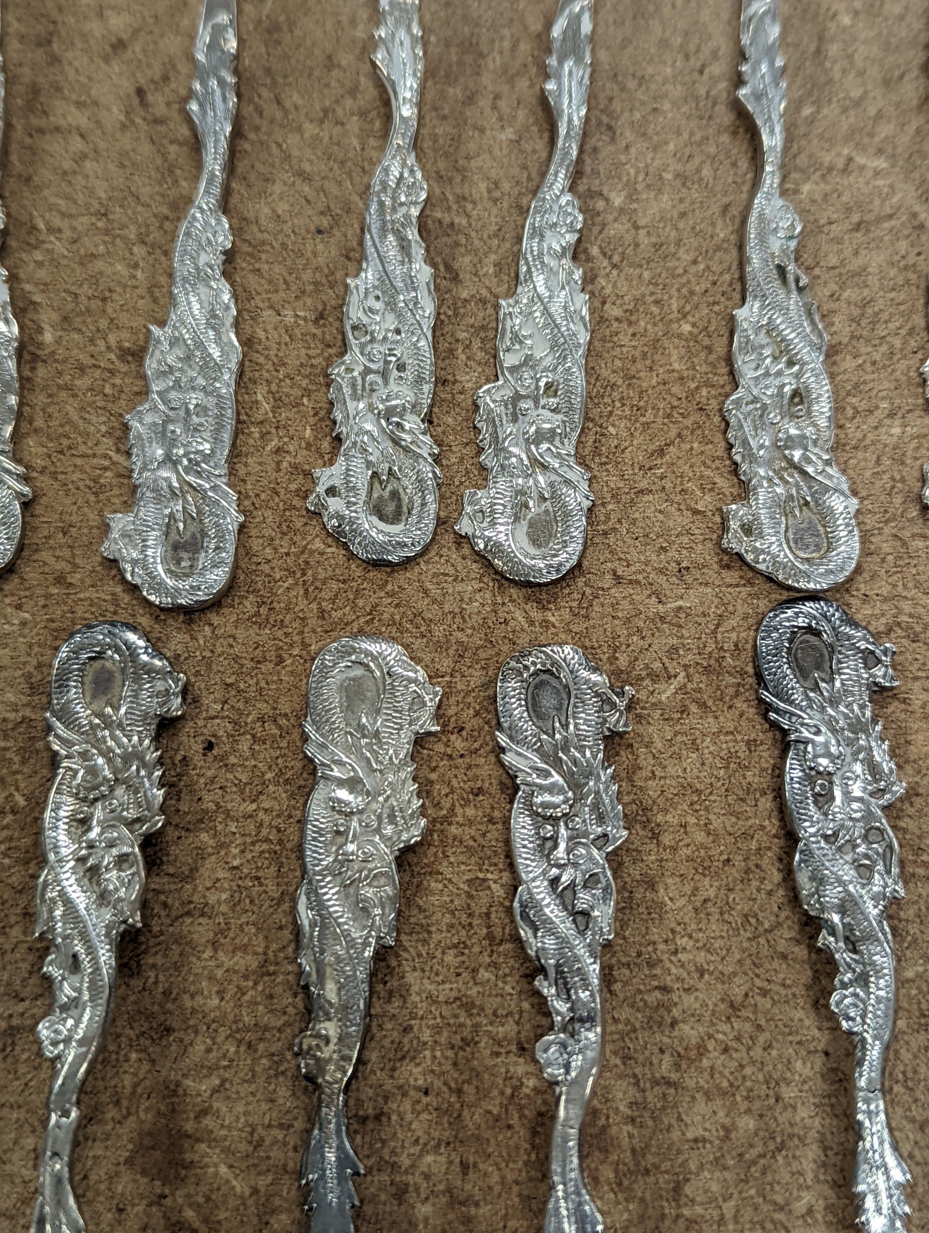 A set of twelve Chinese sterling tea forks, with dragon handles by YCCo and eleven similar teaspoons, 8oz.